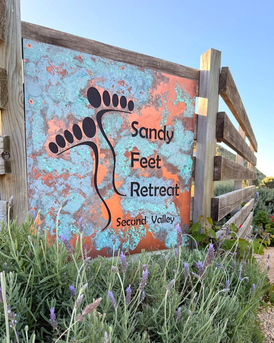 Copper and verdigris Sandy Feet Retreat sign at the gate, Second Valley